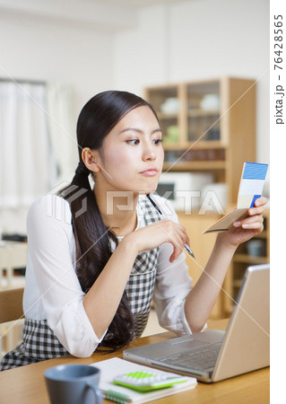 家計簿をつける女性 76428565