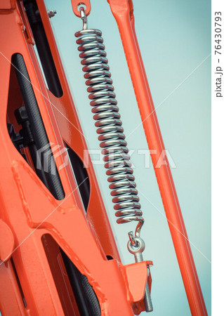 Big and hard steel spring as part and detail of industrial or agricultural machine Big and hard steel spring as part and detail of industrial or agricultural machine 76430793