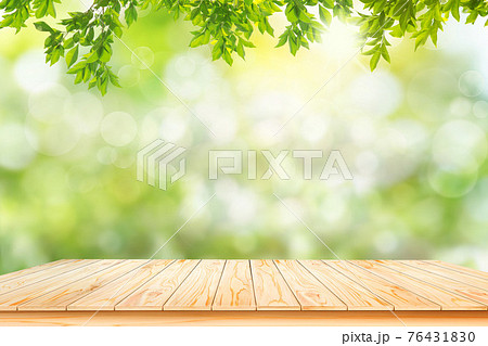 Brown wooden table board empty on fresh and green leaves green bokeh on nature abstract blur background green bokeh from tree.Mock up for display. Brown wooden table board empty on fresh and green leaves green bokeh on nature abstract blur background green bokeh from tree.Mock up for display. 76431830