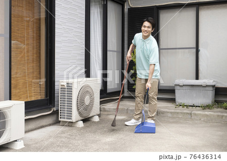 掃き掃除をするハウスクリーニング の男性 76436314
