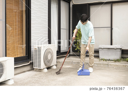 掃き掃除をするハウスクリーニング の男性 76436367