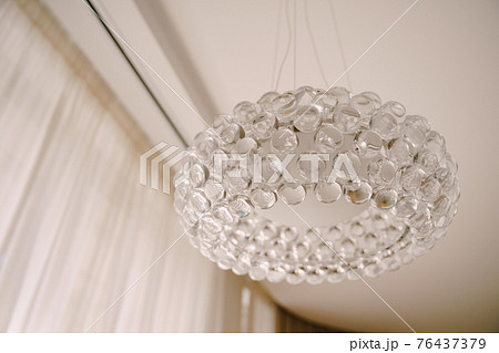 Stylish hi-tech chandelier made of transparent acrylic balls. White light interior style. 76437379