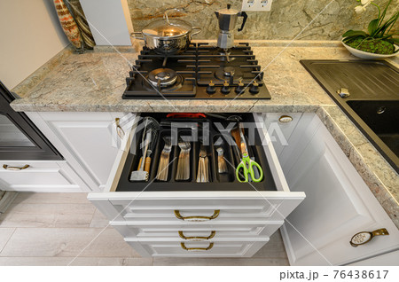 Drawers pulled out at modern classic white kitchen furniture 76438617