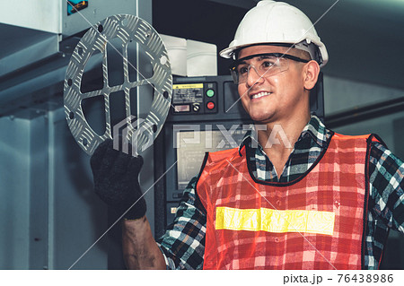 Smart factory job worker looking at machine part in manufacturing workshop Smart factory job worker looking at machine part in manufacturing workshop 76438986