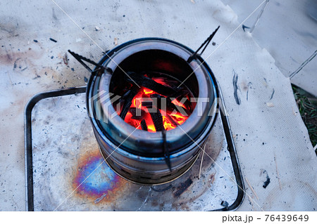 キャンプでウッドストーブで焚き火 76439649
