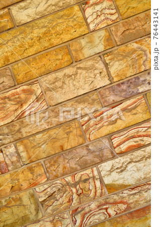 Sturdy yellow and beige cut stone wall, seamless lined up 76443141