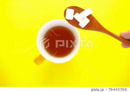cup of tea and sugar cube on spoon cup of tea and sugar cube on spoon 76443769
