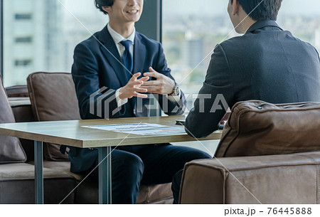 オフィスで会話するビジネスマン 76445888