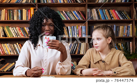 Individual tutor teaches schoolgirl letters with flashcards Individual tutor teaches schoolgirl letters with flashcards 76447574
