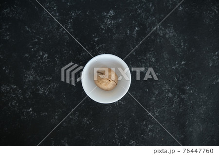 walnuts on a solid black background. Food background. Kitchen. a white plate. top view. 76447760