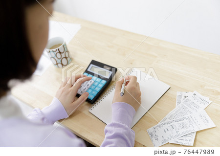家計簿をつける女性 76447989