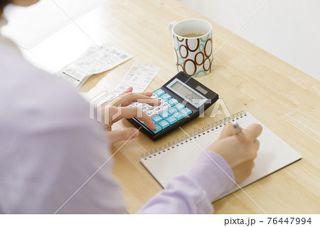 家計簿をつける女性 76447994