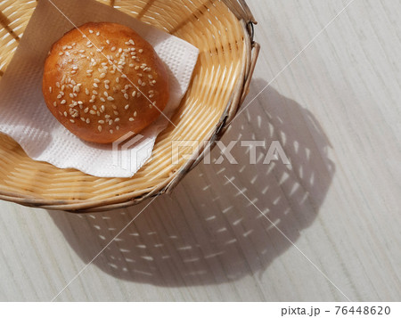 Sunny Breadbasket with long shadow on white wooden table top view. Closeup Bun in basket modern banner snack food decorative design with copy space. Bright Corner bakery flat lay horizontal concept 76448620