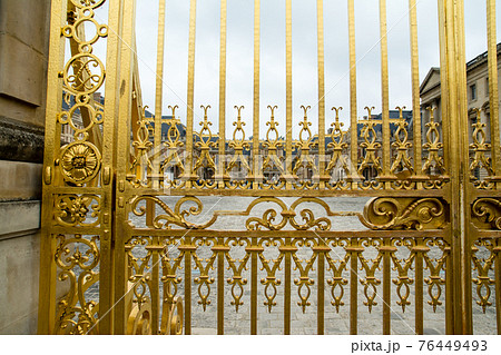 フランスパリのベルサイユ宮殿の金色のゲート柵と遠くに見える宮殿 76449493