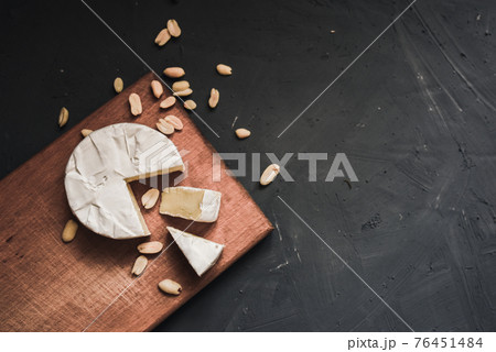 cheese camembert with mold and nuts on wooden board 76451484