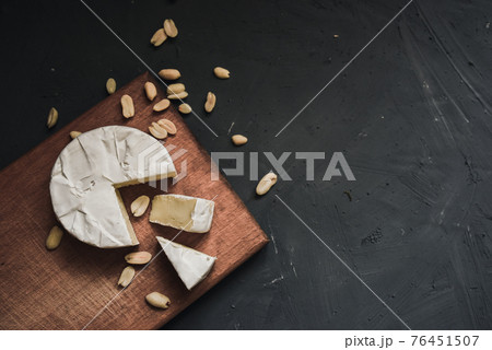 cheese camembert with mold and nuts on wooden board 76451507