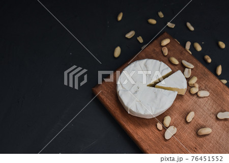 cheese camembert with mold and nuts on wooden board 76451552