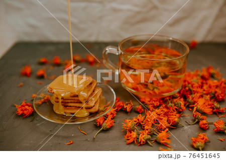 The honey on baked goods. Orange calendula flower tea The honey on baked goods. Orange calendula flower tea 76451645