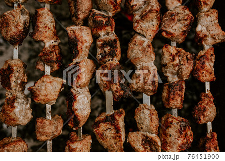 Pork veal cow meat cut into square pieces and fried over a fire Pork veal cow meat cut into square pieces and fried over a fire 76451900