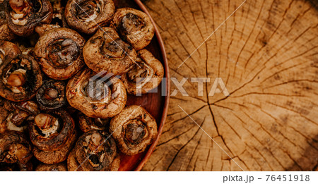 Cooked mushrooms lie on a brown clay plate on a cracked hemp Cooked mushrooms lie on a brown clay plate on a cracked hemp 76451918