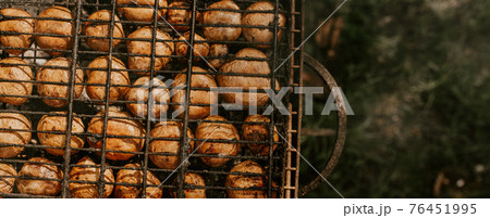 mushrooms champignons stacked in a barbecue on the grill 76451995