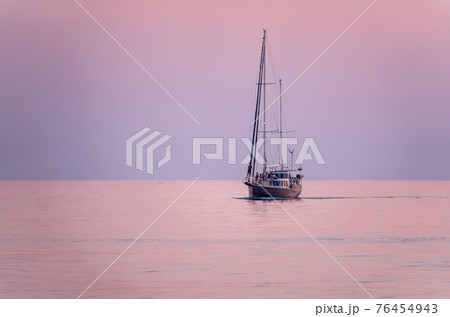 Sailing yacht in the blue sea during beautiful pink sunset. 76454943