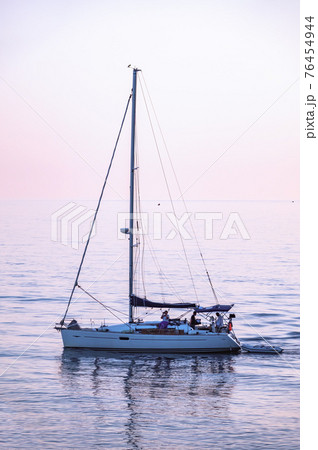 Sailing yacht in the blue sea during beautiful pink sunset. 76454944