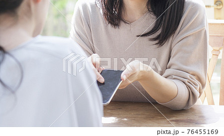 一緒にスマホを見る二人の女性 76455169