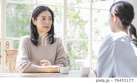 家で話す二人の女性 76455177