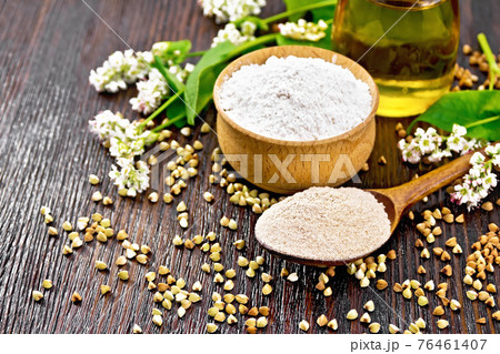 Flour buckwheat brown in spoon with oil on dark board 76461407
