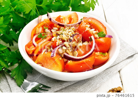 Salad with tomato and walnut in plate on light board Salad with tomato and walnut in plate on light board 76461615