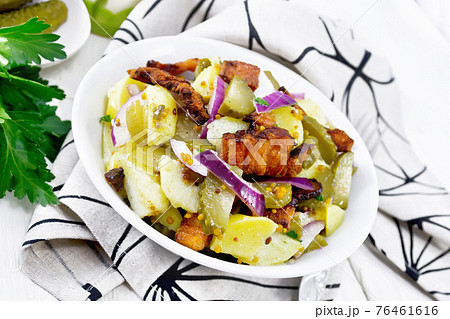 Salad potato with bacon and cucumber in plate on napkin Salad potato with bacon and cucumber in plate on napkin 76461616