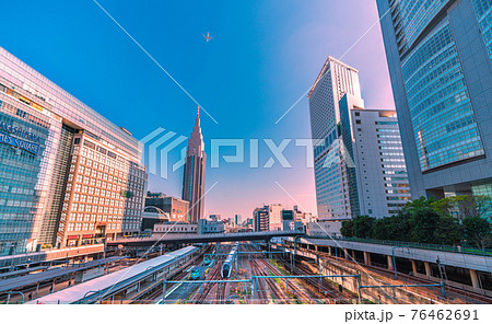 日本の東京都市景観　NTTドコモ代々木ビルや特急などを望む。上空に航空機 76462691
