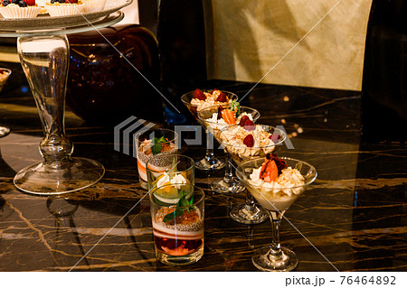 Wedding snacks at the candy bar, sweets and fruit. 76464892