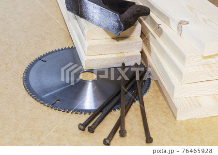 Wooden pine boards . Space for the text. A saw and an old plane. Wooden pine boards . Space for the text. A saw and an old plane. 76465928