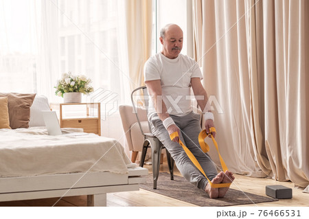 Man sitting on chair doing paschimottanasana or Intense Dorsal Stretch pose Man sitting on chair doing paschimottanasana or Intense Dorsal Stretch pose 76466531