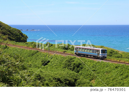 夏の日本海を走る普通列車　海沿いのローカル線風景 76470301