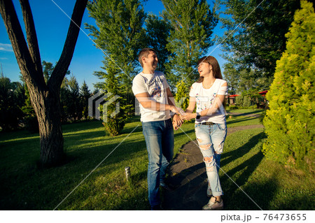 Young romantic couple have fun enjoy each other in green summer park 76473655
