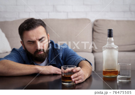 Sad depressed addicted drunk guy having problem, suffer from alcohol addiction Sad depressed addicted drunk guy having problem, suffer from alcohol addiction 76475505