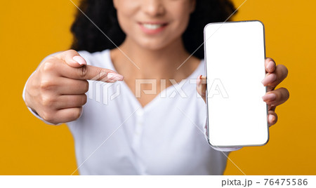 Unrecognizable Smiling Black Lady Pointing On Smartphone With Blank White Screen Unrecognizable Smiling Black Lady Pointing On Smartphone With Blank White Screen 76475586