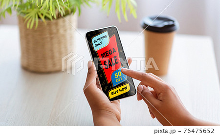 Black woman showing smartphone with shopping application screen 76475652