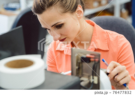 Woman working on label printing machine Woman working on label printing machine 76477832