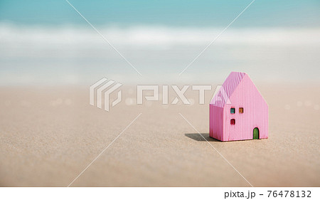Beach House Concept. Mini Colorful Wooden House on the Sand Beach. Destination for Vacation or Retirement Life. Summer Sunny Day. Metaphor Photo 76478132