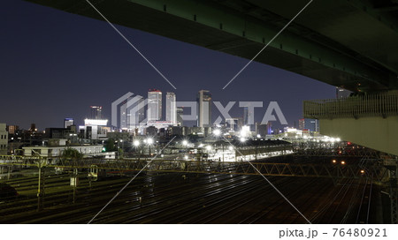 名古屋市の黄金跨線橋から見たJRなどの線路と名古屋駅周辺の高層ビル群の夜景 76480921