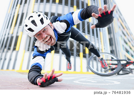 Young male cyclist wearing helmet and protective gear fell off bike and flying portrait Young male cyclist wearing helmet and protective gear fell off bike and flying portrait 76481936