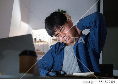 Young man overtime work and feel shoulder and neck pain at home 76482264