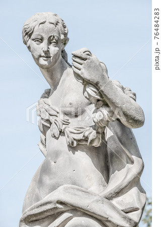 Ancient statue covered with moss and lichen of a sensual renaissance era woman in Potsdam, Germany 76484283