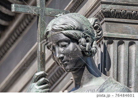 Old metal statue of a sensual woman as a prayer with a cross and covered with spider net in downtown of Dresden, Germany, details, closeup Old metal statue of a sensual woman as a prayer with a cross and covered with spider net in downtown of Dresden, Germany, details, closeup 76484601