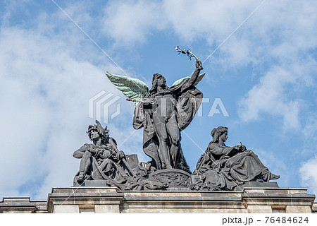Old statue of a black angel as a warrior with green wings at the roof top of the central historical building of Albertinum museum in downtown of Dresden, Germany 76484624