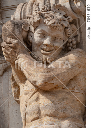 Old sculpture of funny and joyful dickens in downtown of Dresden, Germany, details, closeup 76484630